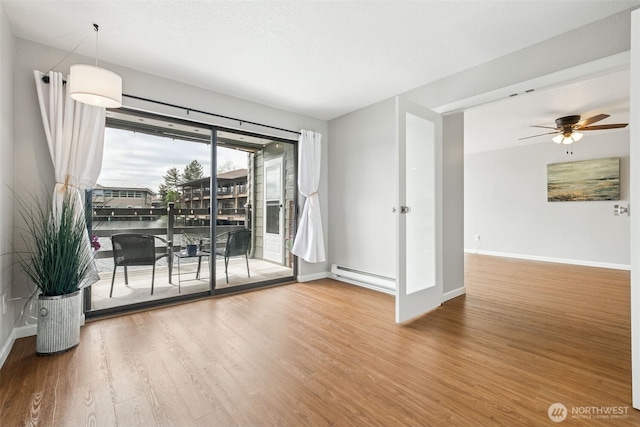 7 Lake Bellevue Dr Unit 109, Bellevue, WA 98005 - unfurnished room with a baseboard radiator, wood finished floors, ceiling fan, and baseboards