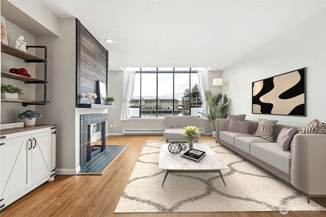 7 Lake Bellevue Dr Unit 109, Bellevue, WA 98005 - living area with a tile fireplace, baseboard heating, light wood finished floors, baseboards, and recessed lighting