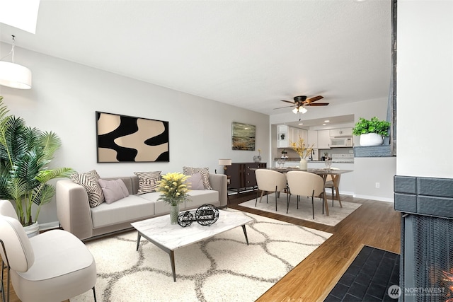 7 Lake Bellevue Dr Unit 109, Bellevue, WA 98005 - living room featuring light wood-style floors, a ceiling fan, and baseboards