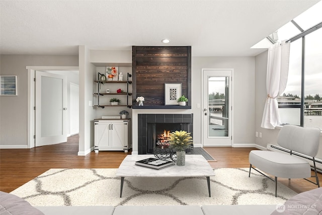 7 Lake Bellevue Dr Unit 109, Bellevue, WA 98005 - living room with wood finished floors, baseboards, a tiled fireplace, baseboard heating, and recessed lighting