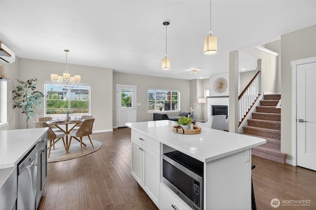 704 Springside Ln, Bellingham, WA 98226 - kitchen featuring appliances with stainless steel finishes, a large fireplace, light countertops, and dark wood-type flooring