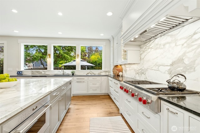 26817 SE 9th Way, Sammamish, WA 98075 - kitchen with stainless steel gas stovetop, plenty of natural light, premium range hood, light stone countertops, and recessed lighting