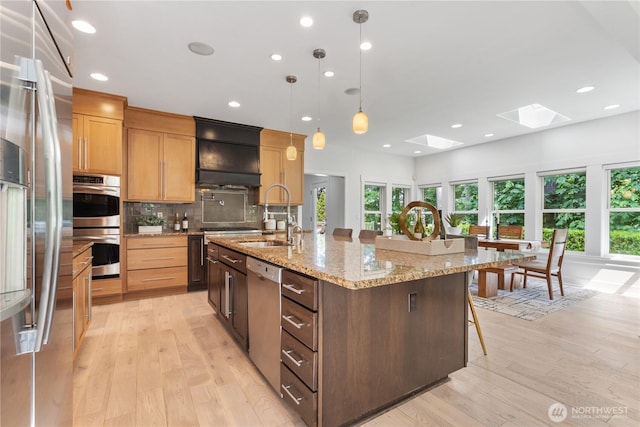 22309 1st Dr SE, Bothell, WA 98021 - kitchen featuring appliances with stainless steel finishes, a skylight, a breakfast bar area, light wood-style flooring, and recessed lighting
