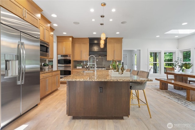 22309 1st Dr SE, Bothell, WA 98021 - kitchen with built in appliances, a skylight, tasteful backsplash, recessed lighting, and a kitchen bar