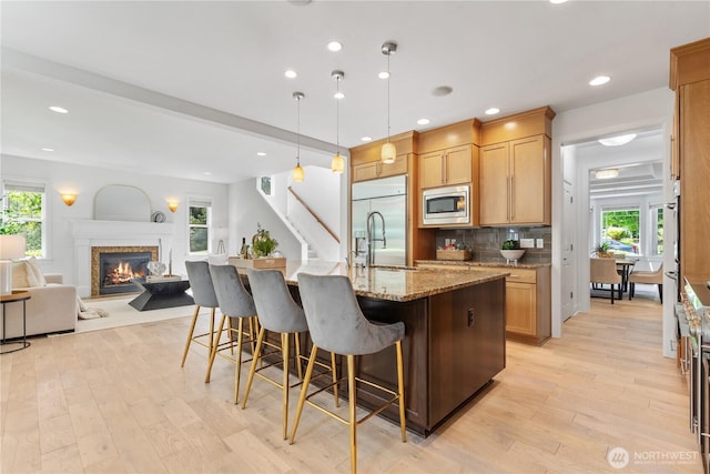 22309 1st Dr SE, Bothell, WA 98021 - kitchen with built in appliances, a sink, light wood-style flooring, a kitchen bar, and recessed lighting