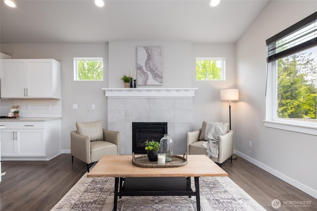 living area featuring healthy amount of natural light, dark wood finished floors, baseboards, and recessed lighting
