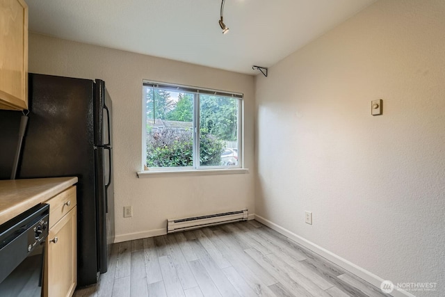 23723 12th Pl S Unit 2005, Des Moines, WA 98198 - kitchen featuring a baseboard radiator, black appliances, light wood-style floors, baseboards, and light countertops