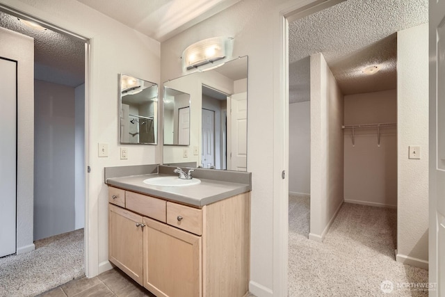 23723 12th Pl S Unit 2005, Des Moines, WA 98198 - full bath featuring vanity, a walk in closet, a textured ceiling, and baseboards