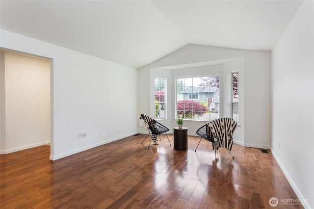 dining room with wood finished floors, lofted ceiling, and baseboards