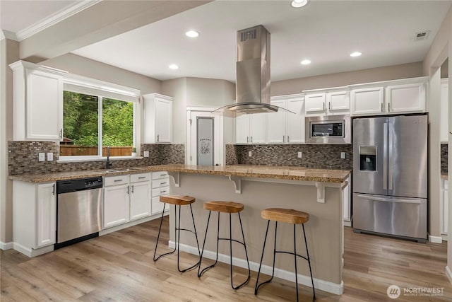 6503 Wrangler Dr SE, Tumwater, WA 98501 - kitchen featuring appliances with stainless steel finishes, island range hood, white cabinetry, recessed lighting, and ornamental molding