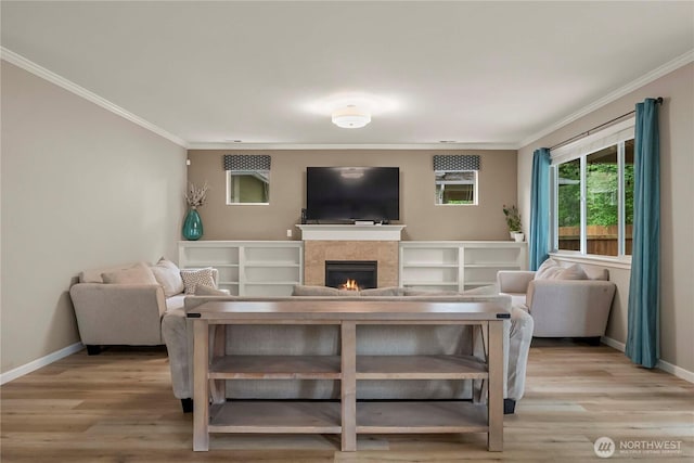 6503 Wrangler Dr SE, Tumwater, WA 98501 - living room featuring crown molding, a warm lit fireplace, baseboards, and light wood-style flooring