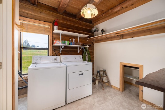 laundry area with separate washer and dryer, wooden ceiling, and wood walls