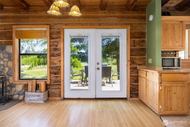 doorway with french doors, beam ceiling, light wood-style flooring, wood ceiling, and a chandelier