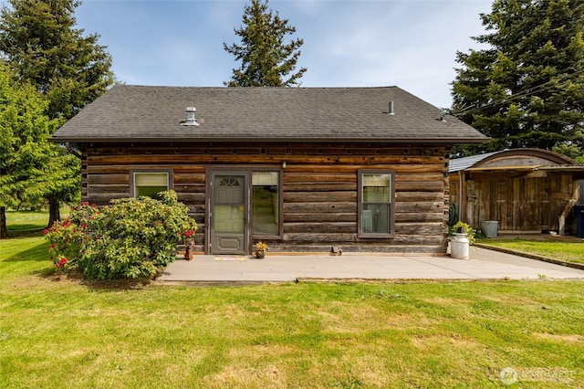 back of house with log siding, a yard, and a shingled roof