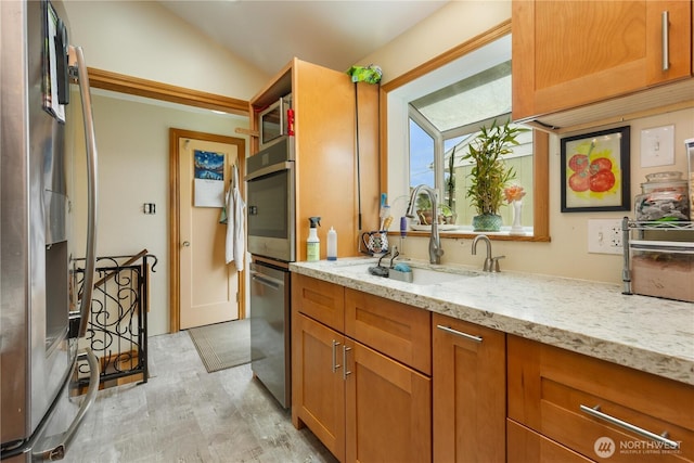 4808 38th Ave SW, Seattle, WA 98126 - kitchen featuring appliances with stainless steel finishes, a sink, light wood finished floors, light stone countertops, and lofted ceiling
