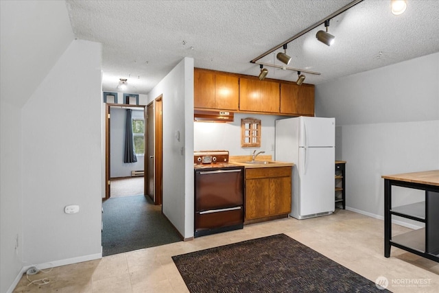 17910 Spruce Way, Lynnwood, WA 98037 - kitchen featuring freestanding refrigerator, range, a sink, brown cabinets, and a textured ceiling