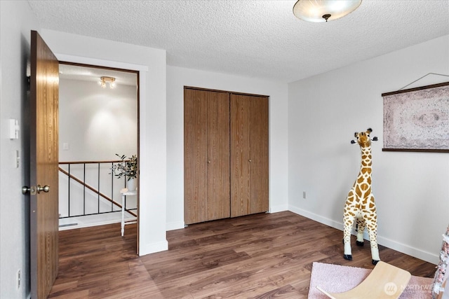 17910 Spruce Way, Lynnwood, WA 98037 - bedroom featuring wood finished floors, a closet, baseboards, and a textured ceiling