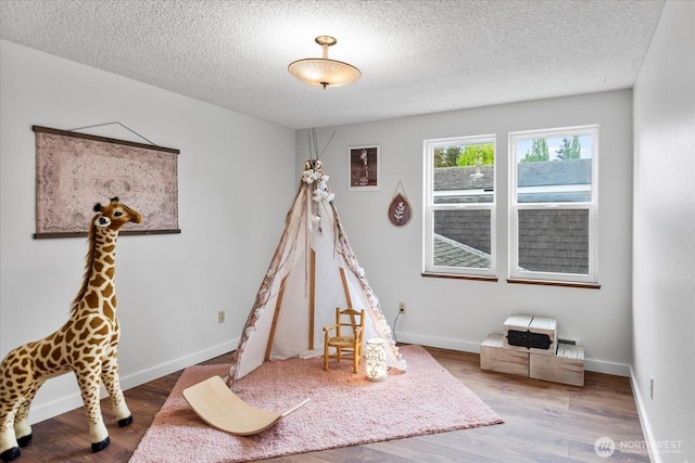 17910 Spruce Way, Lynnwood, WA 98037 - rec room with a textured ceiling, wood finished floors, and baseboards