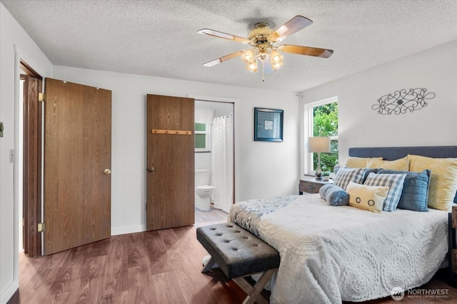 17910 Spruce Way, Lynnwood, WA 98037 - bedroom featuring a textured ceiling, wood finished floors, connected bathroom, a ceiling fan, and baseboards