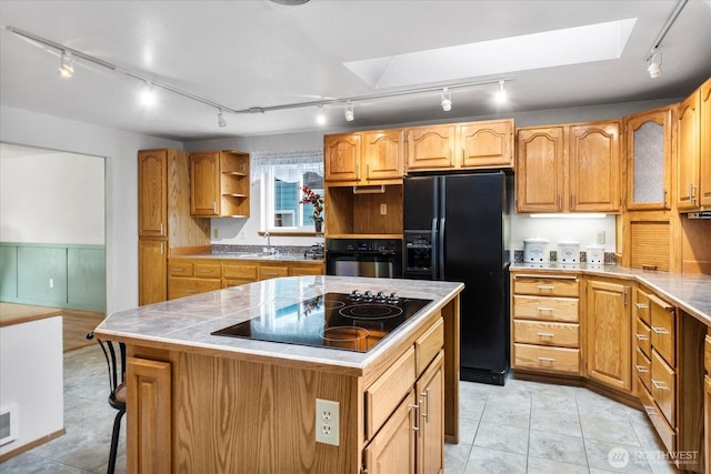 17910 Spruce Way, Lynnwood, WA 98037 - kitchen featuring track lighting, black appliances, a skylight, open shelves, and a kitchen island