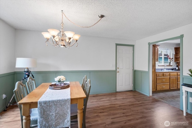 17910 Spruce Way, Lynnwood, WA 98037 - dining area with a wainscoted wall, wood finished floors, a textured ceiling, and a chandelier