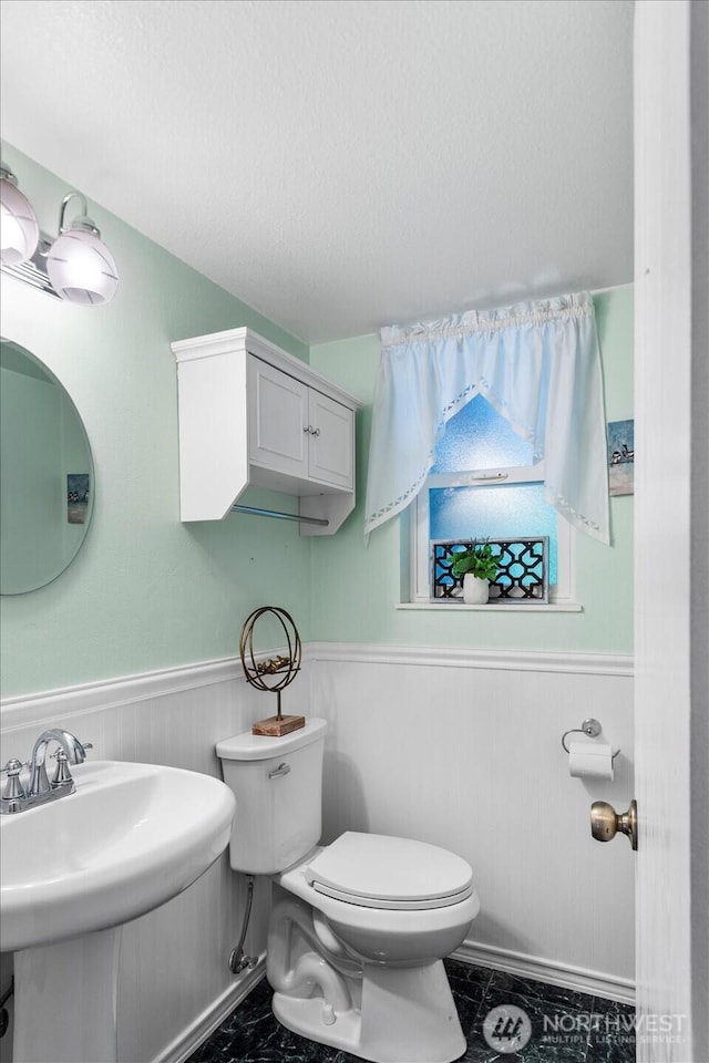 17910 Spruce Way, Lynnwood, WA 98037 - half bathroom featuring toilet, a wainscoted wall, a sink, and a textured ceiling