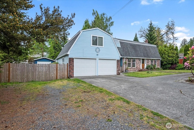 17910 Spruce Way, Lynnwood, WA 98037 - colonial inspired home featuring a gambrel roof, brick siding, driveway, and a shingled roof
