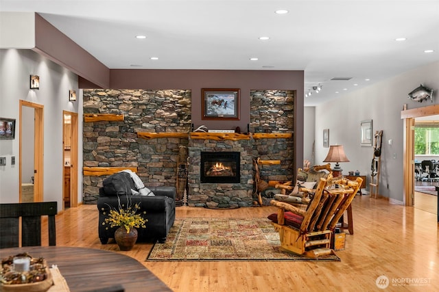 2720 NW Cascade Ave, East Wenatchee, WA 98802 - living room with light wood-style floors, a stone fireplace, and recessed lighting
