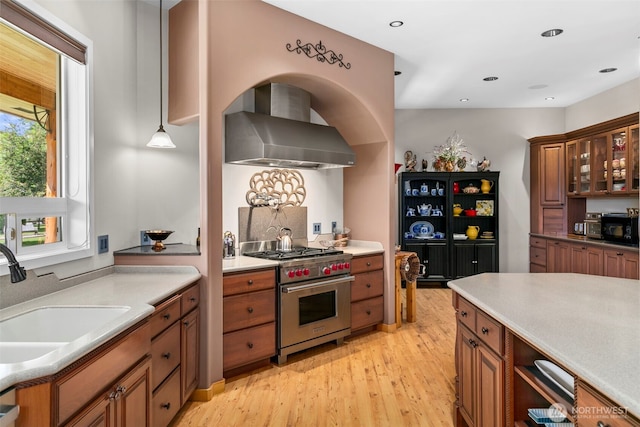 2720 NW Cascade Ave, East Wenatchee, WA 98802 - kitchen featuring luxury stove, wall chimney exhaust hood, black microwave, a sink, and brown cabinets