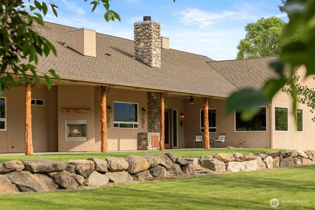 2720 NW Cascade Ave, East Wenatchee, WA 98802 - view of front of house featuring a chimney, a front yard, a shingled roof, a ceiling fan, and stucco siding