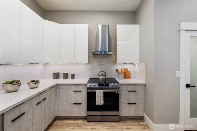 16250 SE Lake Moneysmith, Auburn, WA 98092 - kitchen with stainless steel electric range, wall chimney exhaust hood, decorative backsplash, light wood finished floors, and modern cabinets