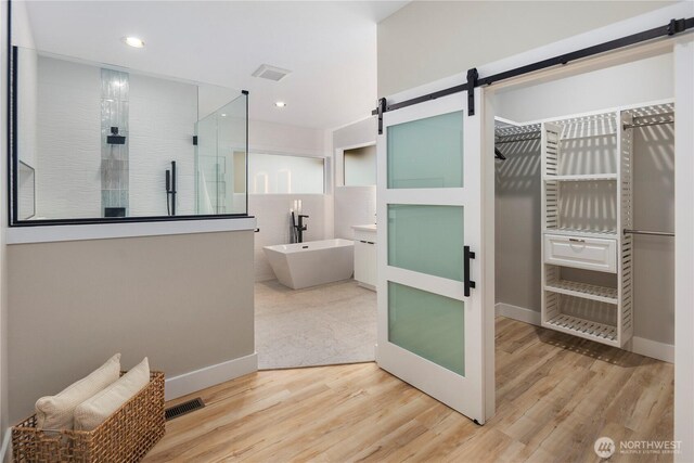16250 SE Lake Moneysmith, Auburn, WA 98092 - bathroom with a tile shower, a freestanding bath, wood finished floors, recessed lighting, and baseboards