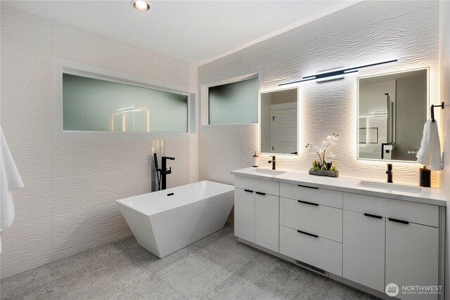 16250 SE Lake Moneysmith, Auburn, WA 98092 - bathroom with double vanity, a freestanding bath, backsplash, recessed lighting, and tile walls