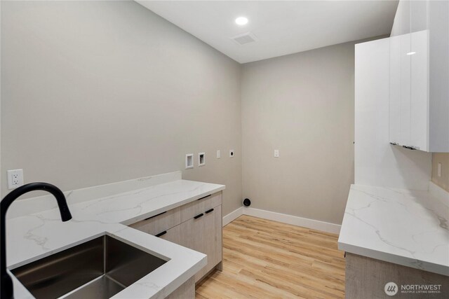 16250 SE Lake Moneysmith, Auburn, WA 98092 - laundry room featuring electric dryer hookup, washer hookup, light wood-style flooring, cabinet space, and baseboards
