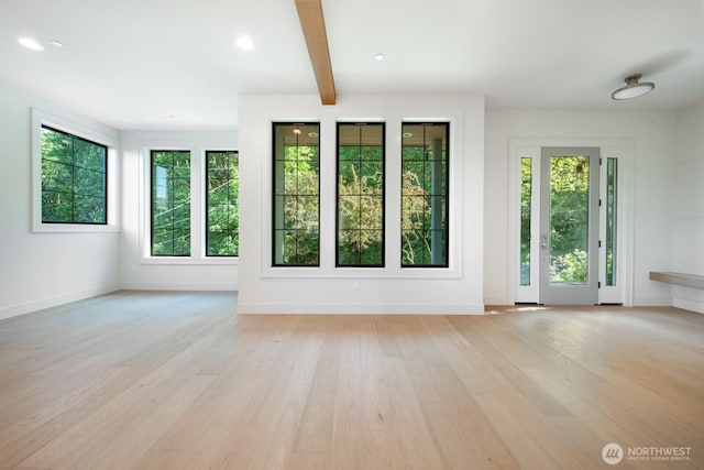 706 N 59th St, Seattle, WA 98103 - unfurnished living room with plenty of natural light, light wood finished floors, baseboards, and beam ceiling