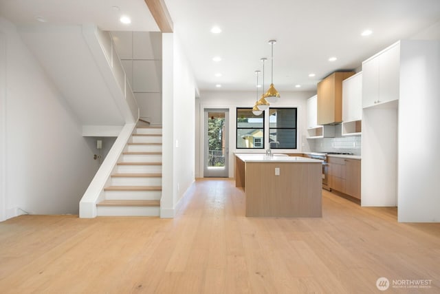 706 N 59th St, Seattle, WA 98103 - kitchen featuring high end stainless steel range, a center island, light wood-type flooring, light countertops, and modern cabinets