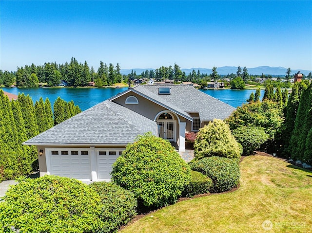 2815 211th Ave E, Lake Tapps, WA 98391 - view of front facade with a shingled roof, a water view, a front lawn, stucco siding, and an attached garage