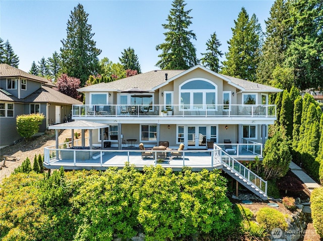 2815 211th Ave E, Lake Tapps, WA 98391 - back of property with french doors, a deck, and stucco siding