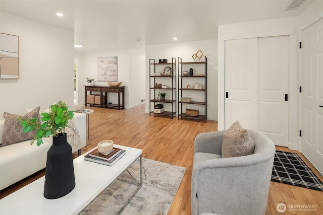 living area featuring light wood-type flooring and recessed lighting