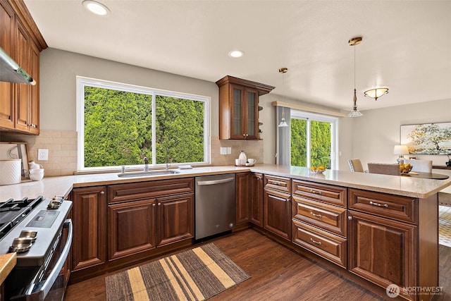 kitchen with stainless steel appliances, a sink, a peninsula, recessed lighting, and glass insert cabinets