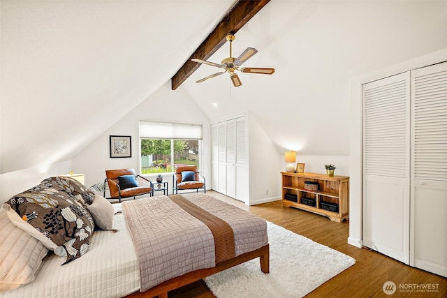 bedroom featuring two closets, wood finished floors, and ceiling fan