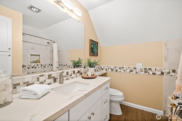 bathroom featuring vaulted ceiling, wood finished floors, toilet, a shower with shower curtain, and tile walls