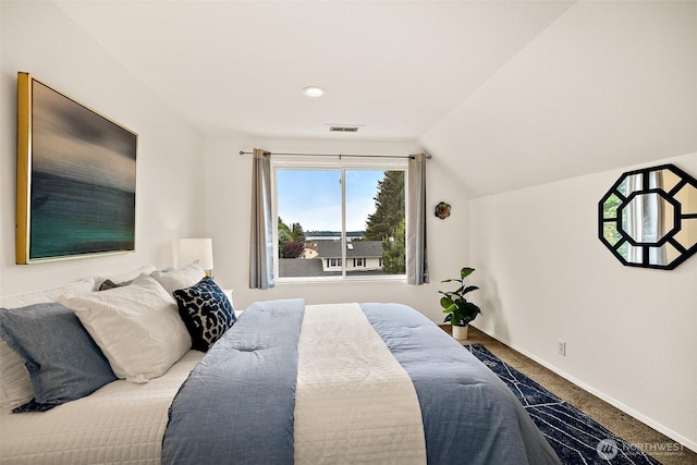 carpeted bedroom featuring lofted ceiling and baseboards