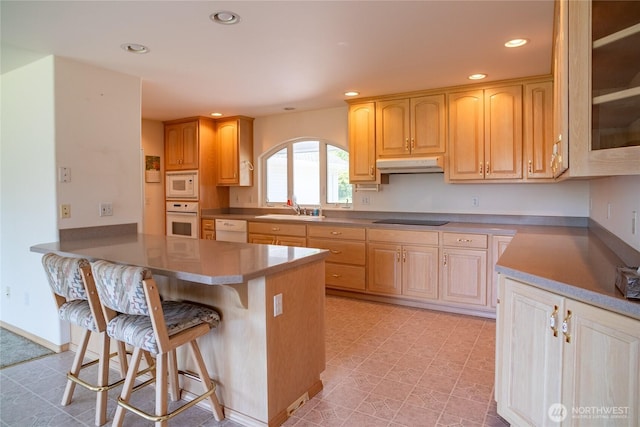 28705 48th Ave NW, Stanwood, WA 98292 - kitchen featuring white appliances, under cabinet range hood, a kitchen bar, recessed lighting, and a peninsula