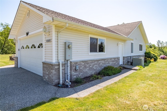 28705 48th Ave NW, Stanwood, WA 98292 - view of side of home featuring a shingled roof, a yard, asphalt driveway, brick siding, and a garage