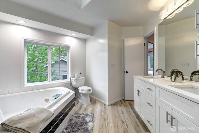 17634 118th Ave SE, Renton, WA 98058 - bathroom featuring toilet, plenty of natural light, a tub with jets, and wood finished floors