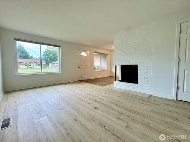 8312 121st St SW, Lakewood, WA 98498 - unfurnished living room with wood finished floors, a brick fireplace, and baseboards
