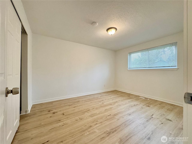 8312 121st St SW, Lakewood, WA 98498 - unfurnished bedroom with wood finished floors, a closet, a textured ceiling, and baseboards