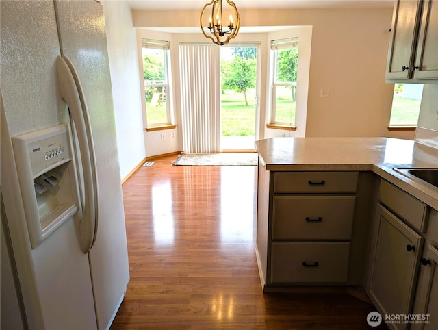 9441 180th Way SW, Rochester, WA 98579 - kitchen featuring white fridge with ice dispenser, dark wood-style floors, light countertops, a chandelier, and a peninsula