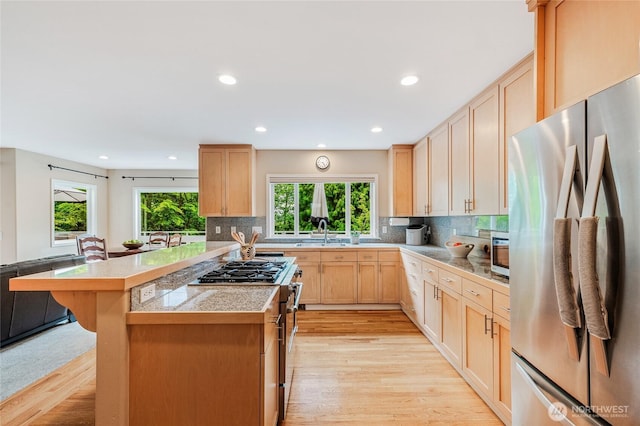 11120 NE 106th Pl, Kirkland, WA 98033 - kitchen with appliances with stainless steel finishes, light brown cabinetry, light wood-type flooring, a sink, and tasteful backsplash